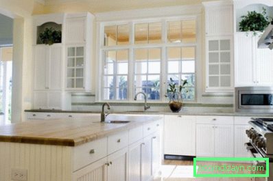 бело-дрвени-кухињски ормари-светли-мраморни-тоалет-светло-дрвени-лакирани-под-бела-керамика-плочасти-бацкспласх-бела-обојена-дрвени-оквир-прозор-светла-кухиња